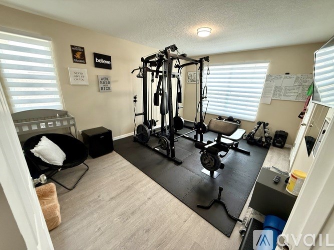 A home gym with a variety of equipment including a treadmill, weights, and a bench.