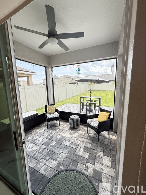 A patio with a ceiling fan and a table with chairs.
