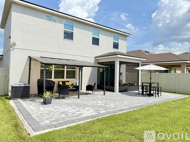 A modern house with a patio and outdoor furniture.