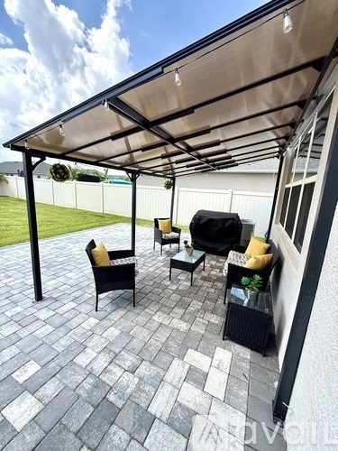 A patio with a black table and chairs under a canopy.