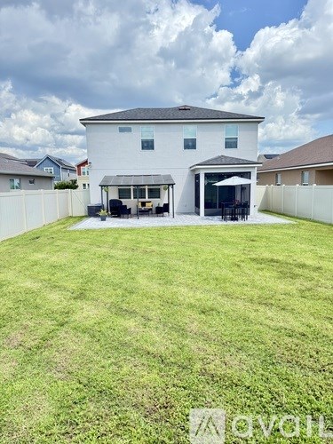 A white house with a large lawn in front.
