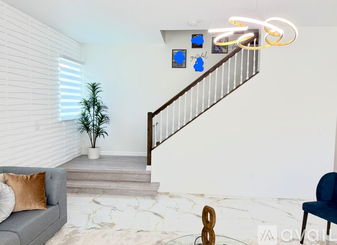 A living room with a grey sofa, a coffee table, and two chairs.
