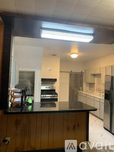 A kitchen with a black countertop and wooden cabinets.