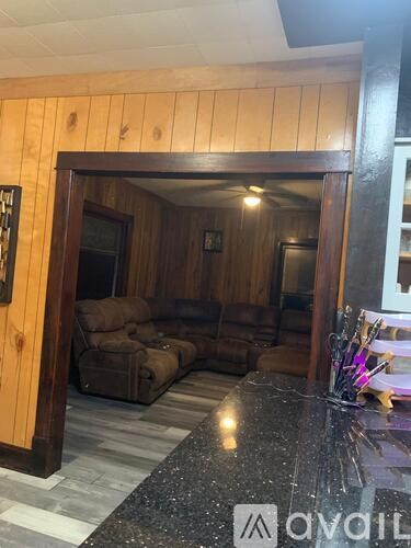 A wooden room with a black granite countertop and a logo that reads "avail".