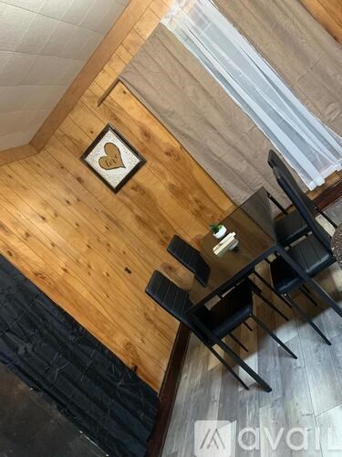 A wooden table with four chairs and a heart-shaped decoration on the wall.