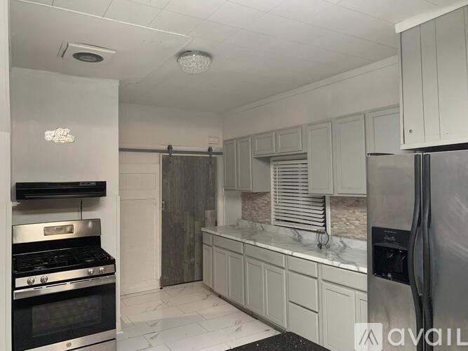 A kitchen with a stove top oven and a refrigerator.
