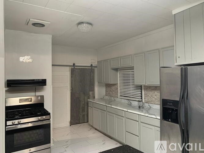 A kitchen with a stove top oven and a refrigerator.