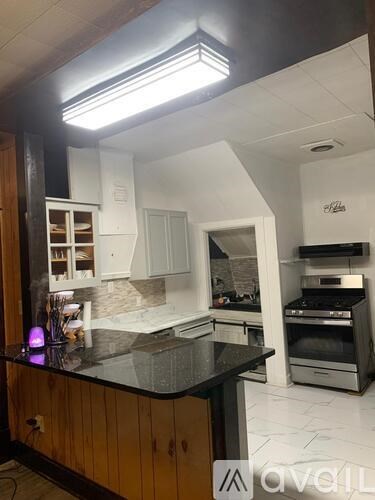 A kitchen with a black countertop and wooden cabinets.