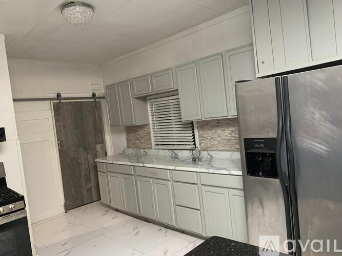 A kitchen with a refrigerator on the right side.