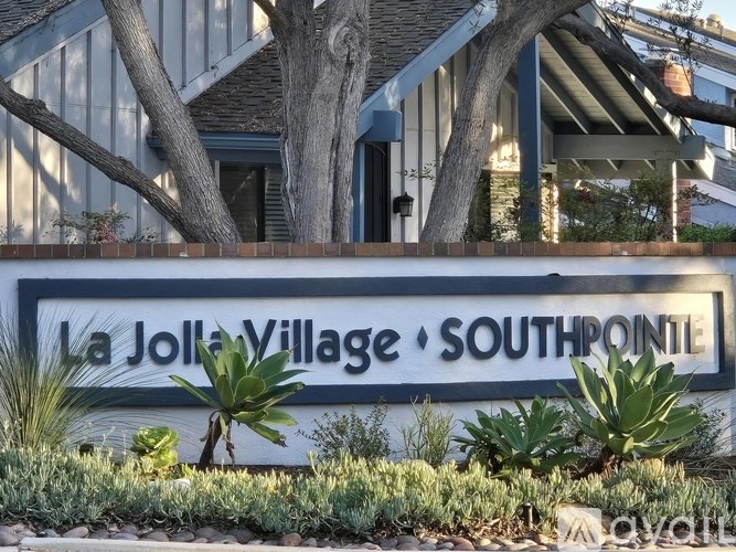 A sign that says La Jolla Village Southpointe is in front of a house.