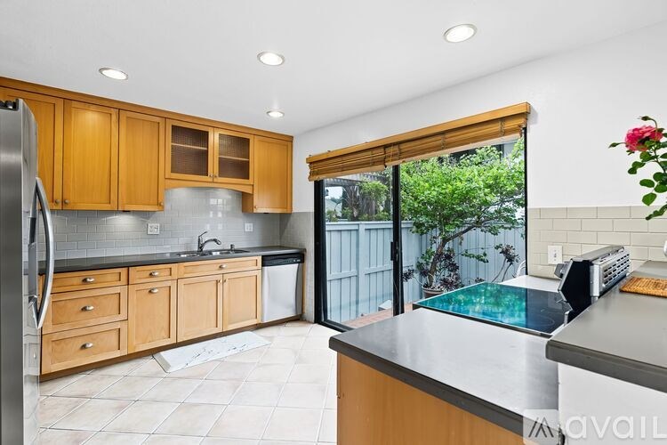 A kitchen with wooden cabinets and a tiled floor.