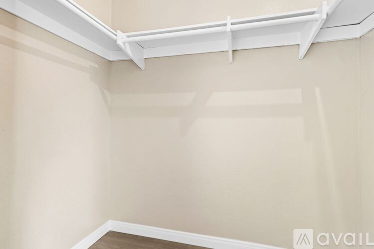 A grassy field with trees and a person lying on the grass.