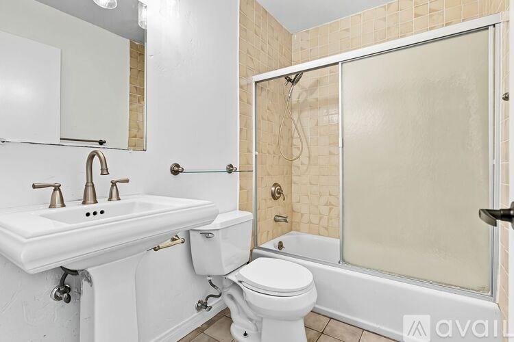 A white bathroom with a sink, toilet and shower.