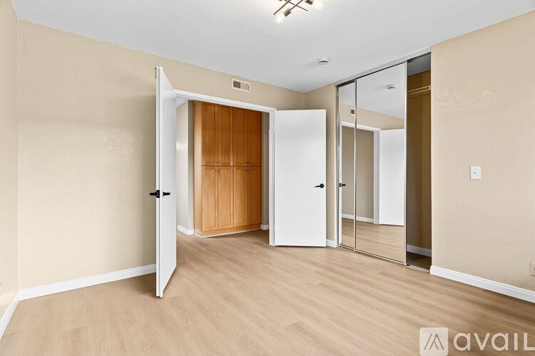 A room with a white door and a mirror on the wall.