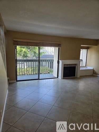 A living room with a television and sliding glass doors.