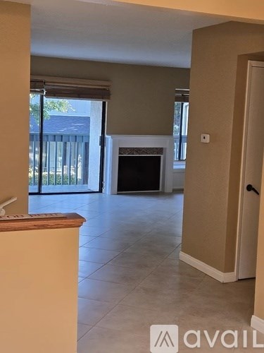 A living room with a fireplace and sliding glass doors.