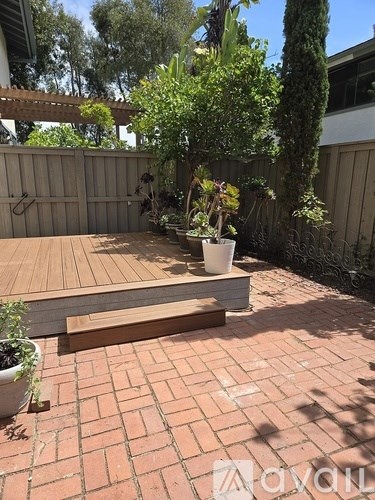 A patio with a bench and potted plants.