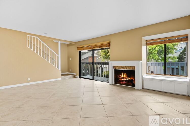 A room with wooden flooring and a window showing an outdoor view.