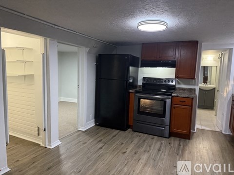 A room with wooden flooring and a window with blinds.