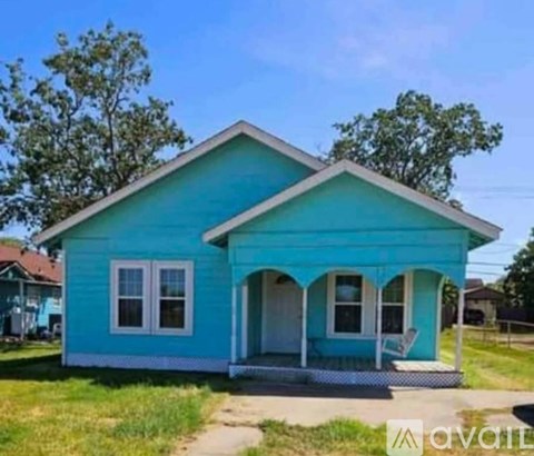 A blue house with a porch and a white door.