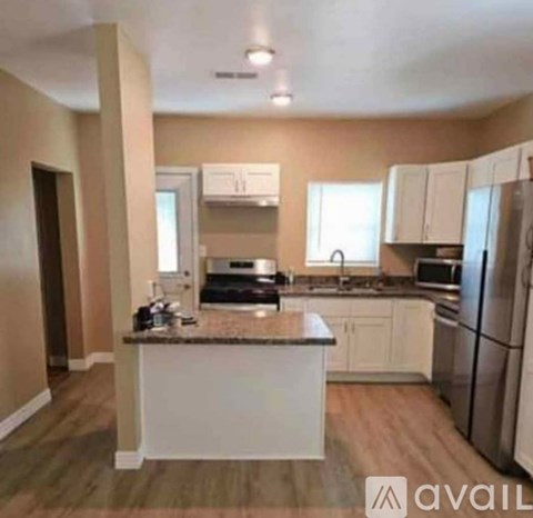 A kitchen with white cabinets and a granite countertop.