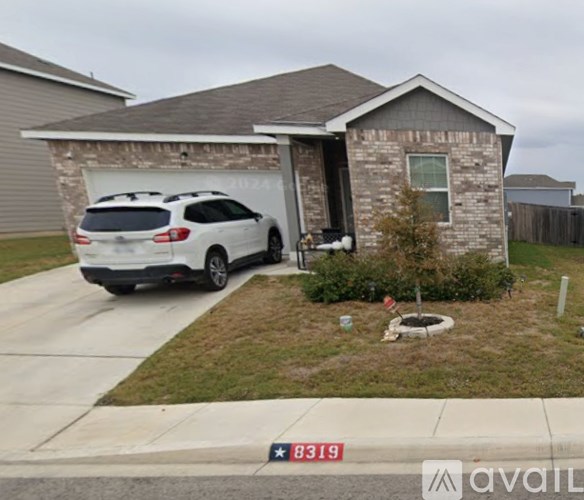A white car is parked in front of a house with the number 8319 on the street.