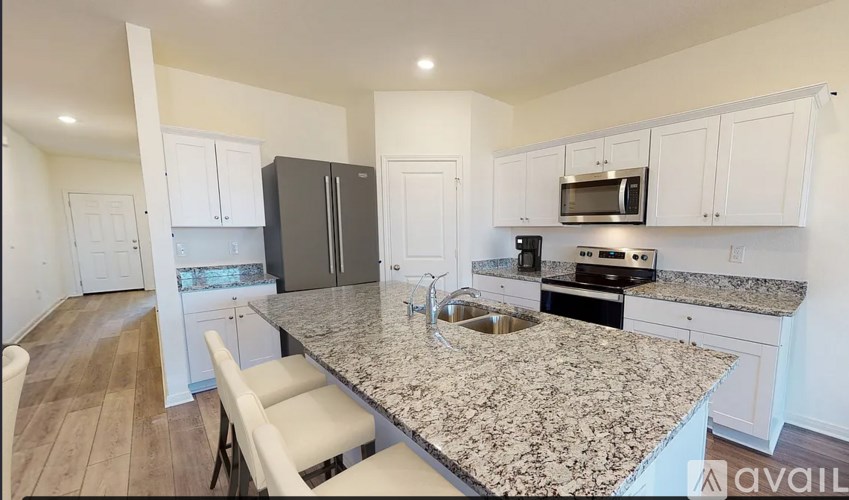 A kitchen with granite countertops and white cabinets.