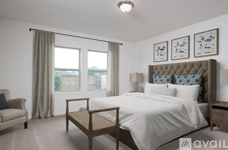A bedroom with a large bed, a chair, and a window with a view of the city.