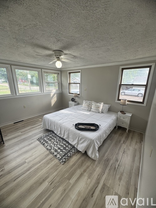 A bedroom with a bed, nightstand, and window.