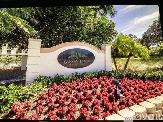 A garden with a sign that says "Banyan Tree" in front of a building.