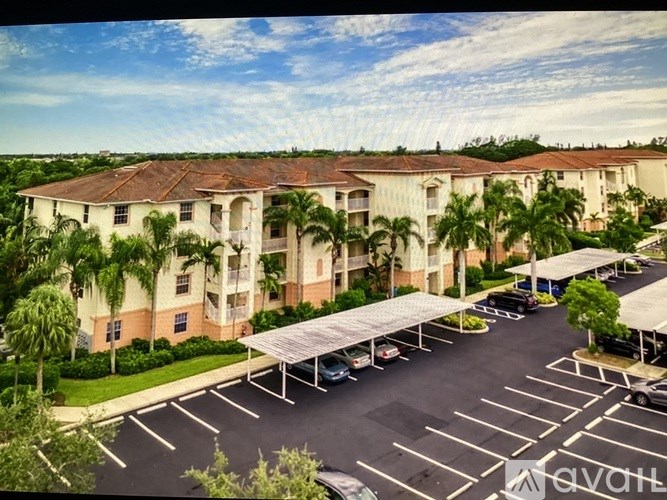 A parking lot in front of a building with a canopy.