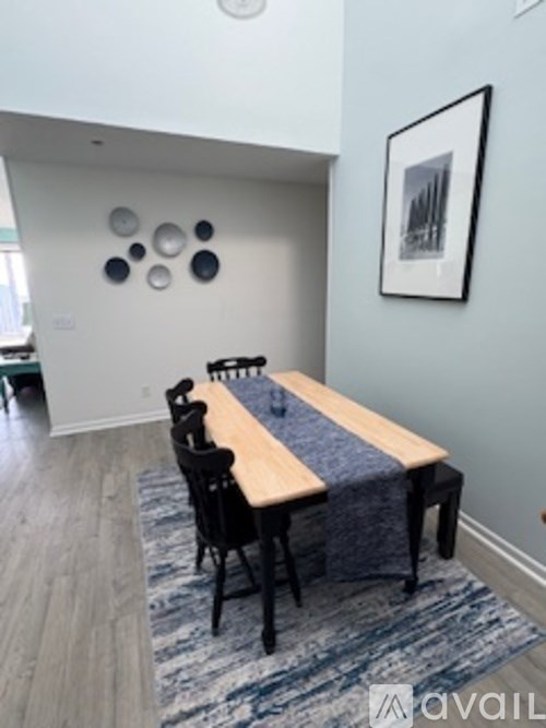 A dining room with a wooden table and chairs.