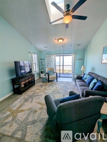 A living room with a television, couch, and a rug.