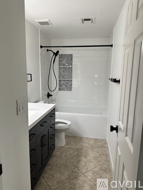 A bathroom with a toilet, sink, and bathtub.