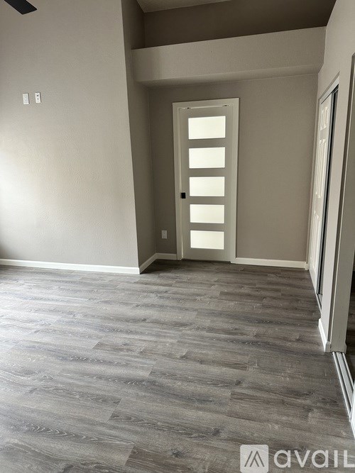 A room with a grey floor and a white door.