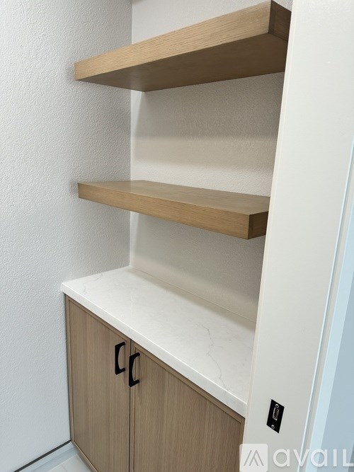 A white shelf with two shelves and a cabinet with two doors.