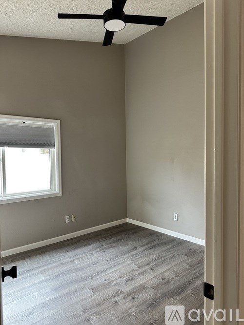 A room with a ceiling fan and a window.