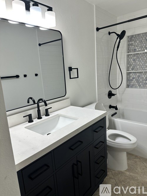 A bathroom with a sink, toilet, and a mirror.