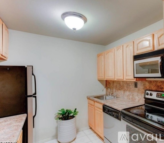 A kitchen with wooden cabinets and a black stove top oven.