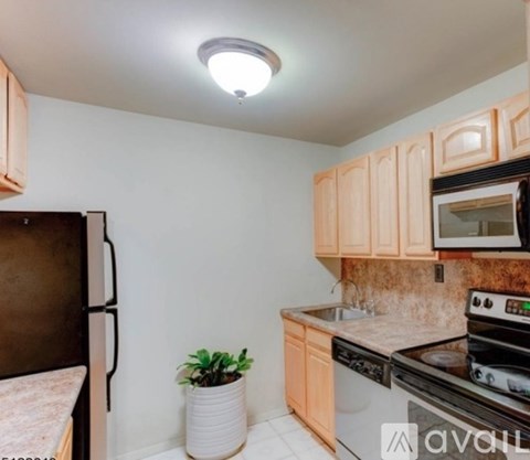 A kitchen with wooden cabinets and a black stove top oven.