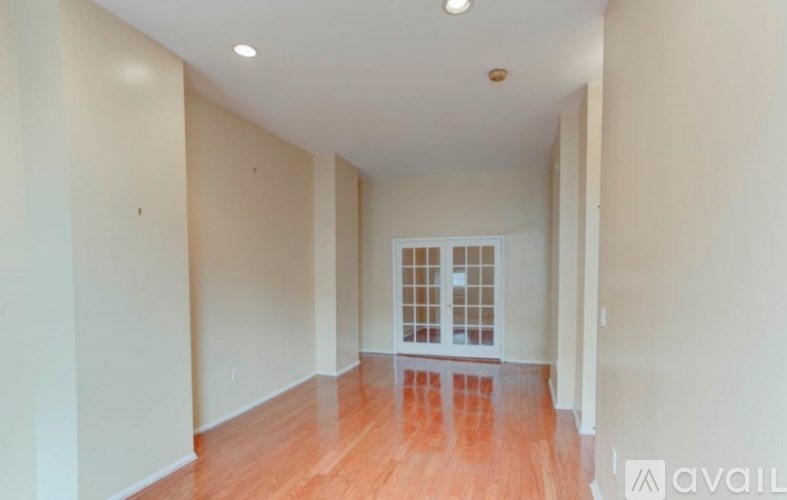 A room with wooden floors and a window with a white frame.