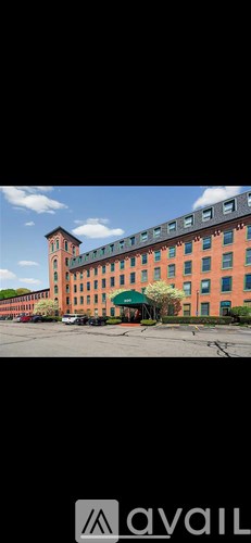A large building with a tower and a green awning.