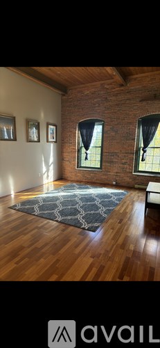 A room with wooden floors and a brick wall.