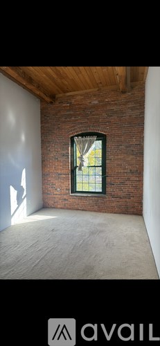 A room with a brick wall and a window.