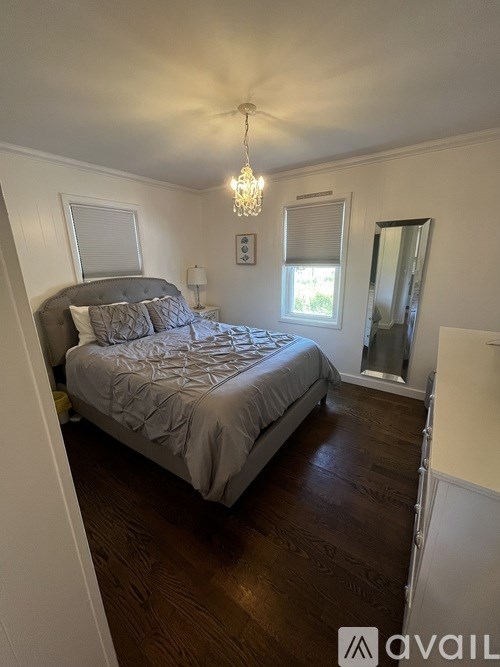 A bedroom with a large bed and a chandelier.
