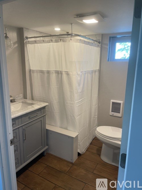 A living room with wooden floors and a stone pillar.
