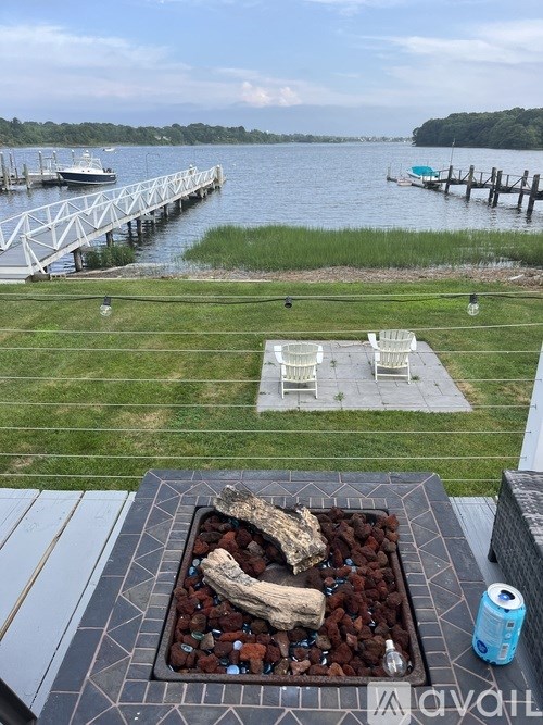 A backyard with a fire pit and a view of a dock.