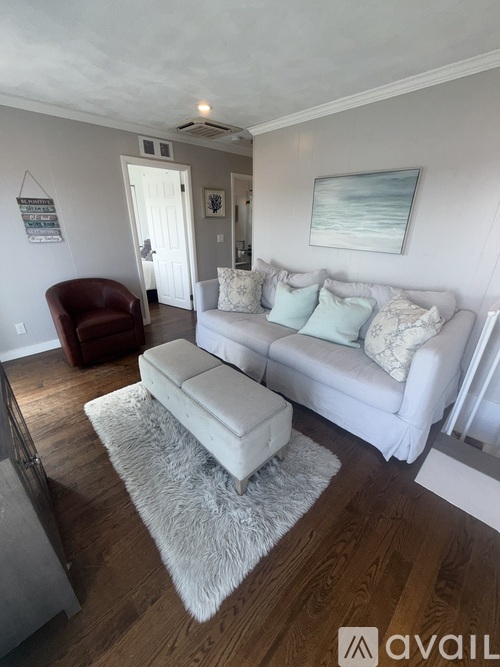 A living room with a cowhide rug on the floor.