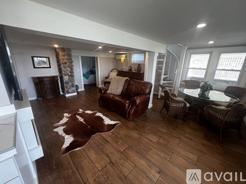 A living room with a cowhide rug on the floor.