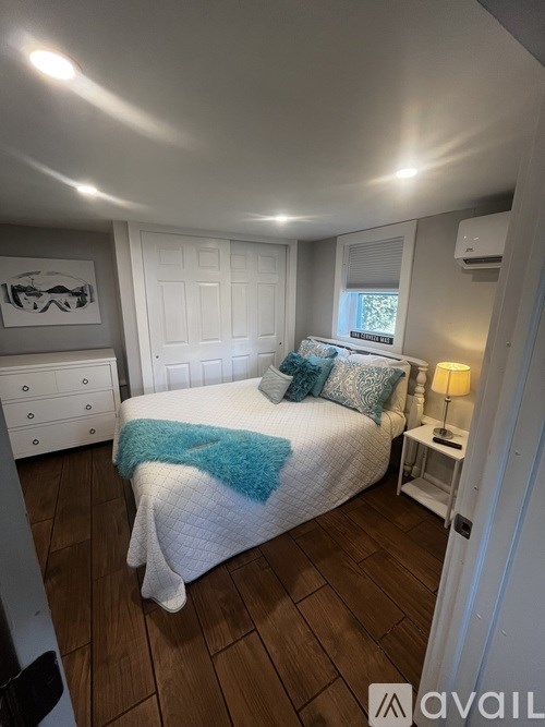A bedroom with a bed, nightstand, and window.